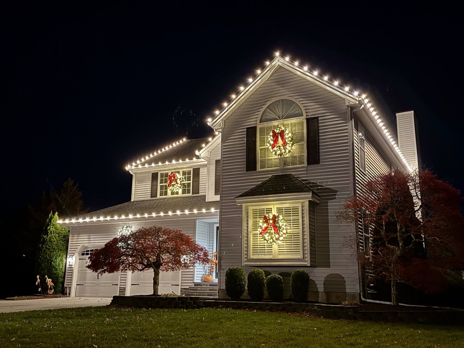 South Jersey home with warm white holiday roofline lights and wreaths in the windows